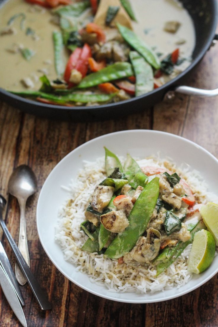 a white plate topped with rice and veggies next to a skillet filled with chicken