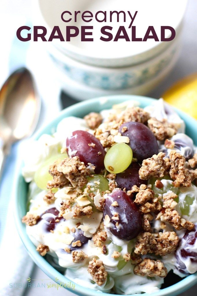 a bowl filled with grapes and granola on top of a table