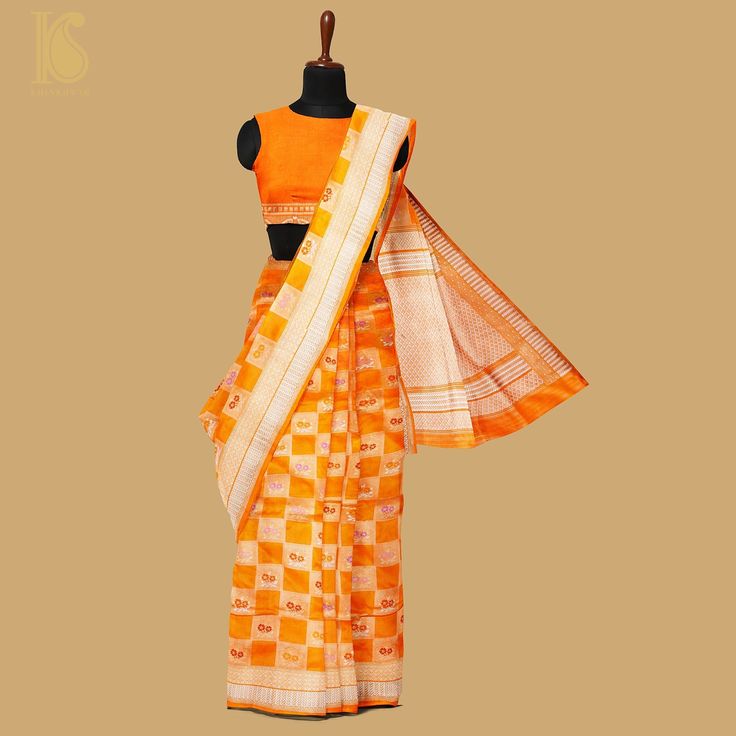 Khinkhwab's Katan Silk saree epitomizes timeless grace and luxury. Meticulously crafted with pure silk, the fabric boasts a smooth and lustrous texture, highlighting the traditional Katan weave known for its fine and tight pattern. This saree offers an elegant drape and a luxurious feel against the skin. Khinkhwab's Katan Silk saree is a fusion of heritage and modern sophistication. Each piece tells a story of craftsmanship and attention to detail, making it a symbol of refinement. Experience th Traditional Orange Pre-draped Saree With Zari Weaving, Traditional Chanderi Pre-draped Saree With Weaving Work, Orange Handloom Pre-draped Saree For Puja, Elegant Blouse Piece For Puja With Weaving Work, Elegant Blouse Piece With Weaving Work For Puja, Traditional Katan Silk Saree With Woven Motifs, Slub Silk Saree With Woven Motifs For Wedding, Wedding Saree In Cotton Silk With Weaving Work, Orange Handloom Art Silk Pre-draped Saree