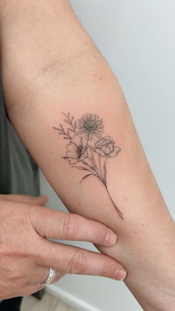 a woman's arm with a flower tattoo on the left side of her arm