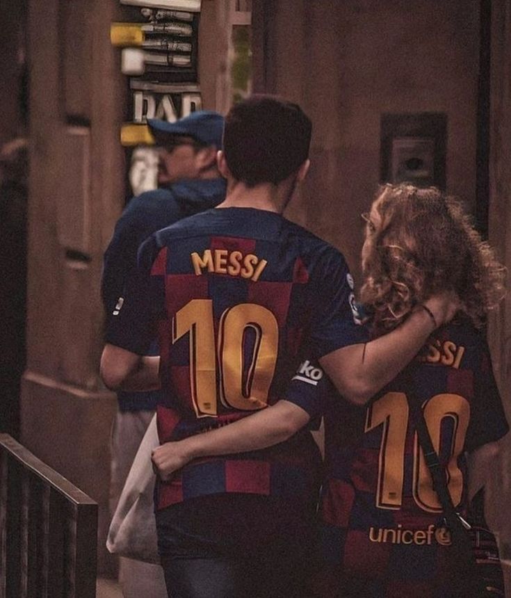 two soccer players walking down the street with their arms around each other's shoulders