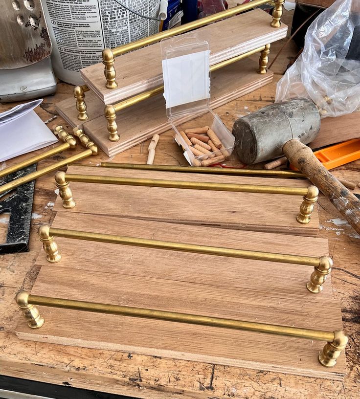 some tools are laying out on a workbench with wood planks and brass handles