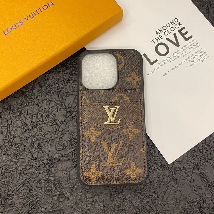 a louis vuitton phone case sitting on top of a table next to a box