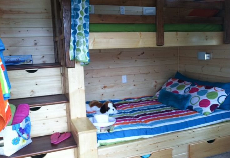 a bunk bed in a room with wooden walls