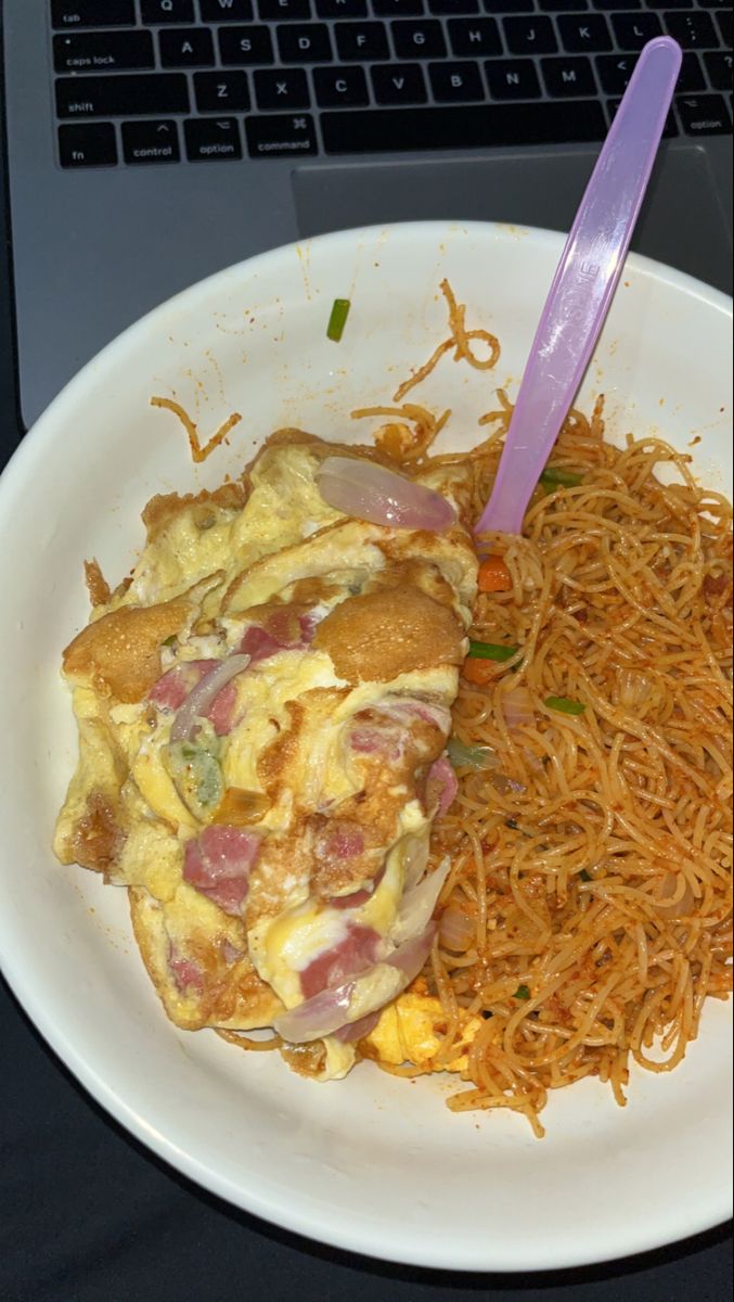 a white plate topped with food next to a laptop