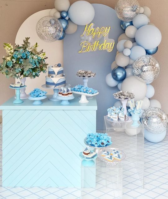 a blue and white birthday party with balloons