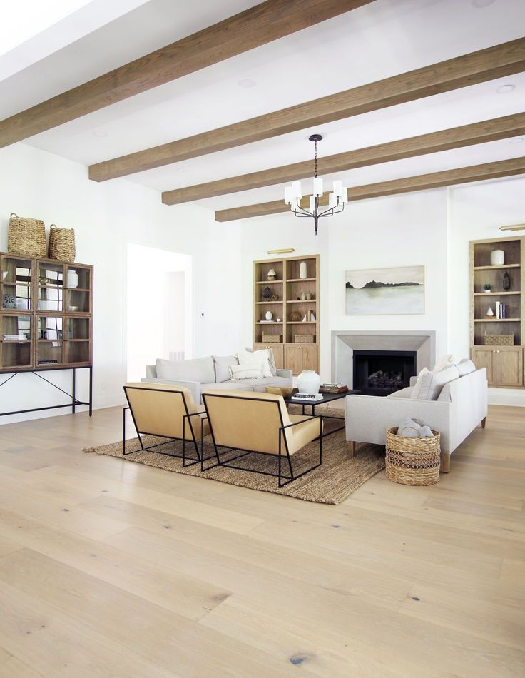 a living room filled with furniture and a fire place next to a book shelf on top of a hard wood floor