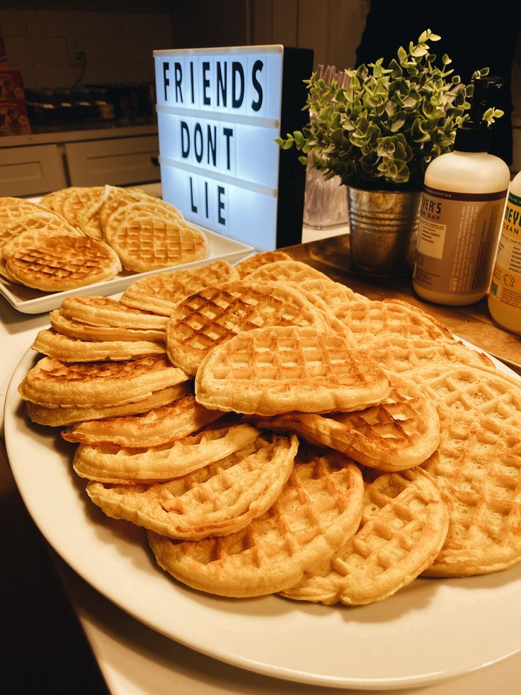 some waffles are on a white plate and there is a sign that says friends don't lie