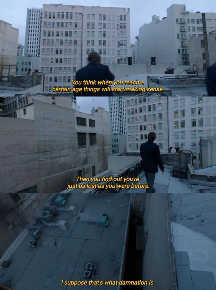 a man standing on top of a roof next to tall buildings with words written below