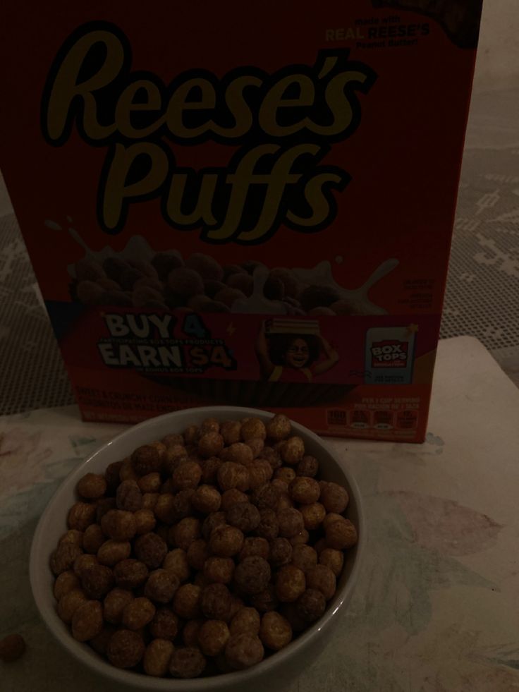 a box of reese's puffs next to a bowl of cereal