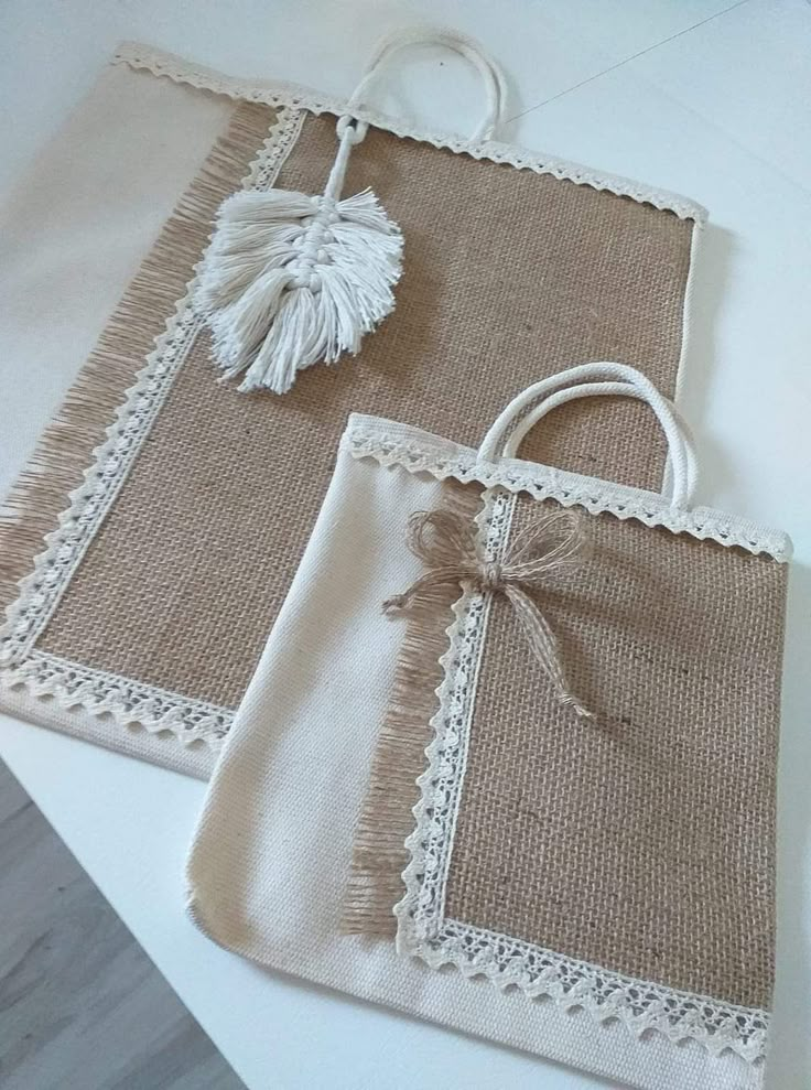 two burlap bags with tassels on them sitting on top of a table