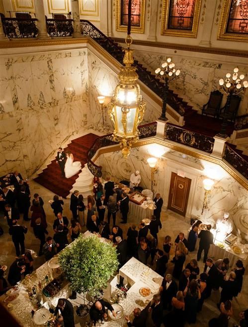 an overhead view of people standing in the middle of a hall with chandeliers