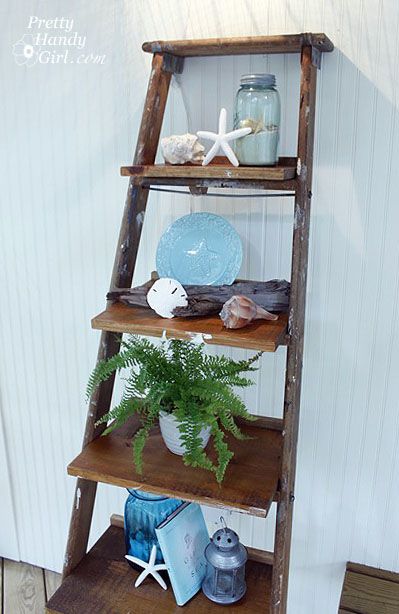 a wooden ladder shelf with plates and vases on it next to a potted plant