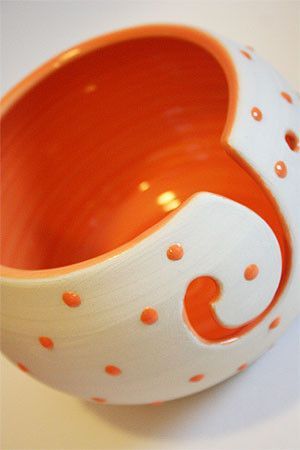 an orange and white bowl sitting on top of a table