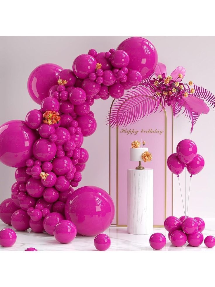 pink balloons are floating in the air next to a white vase with flowers on it