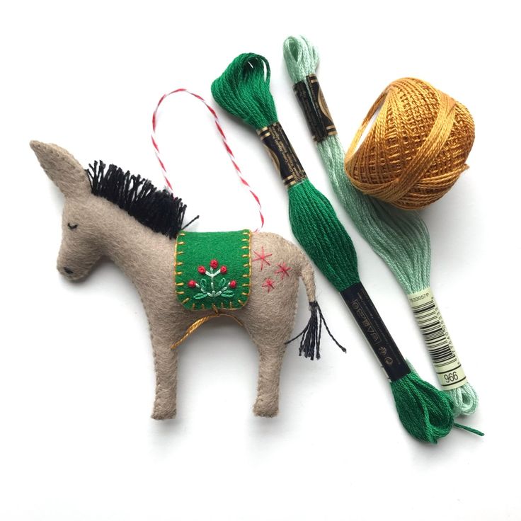 two small toy horses are next to yarn