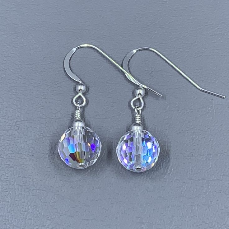 This pair of earrings is simply sparkling! The Swarovski Crystal disco ball is accented with a sterling silver bead that has been hand wire wrapped in sterling silver and on sterling silver French ear wires. These earrings are eye-popping but yet give a subtle sparkle. Sparkling Round Metal Crystal Earrings, Bohemian Nickel-free Dangle Crystal Earrings, Bohemian Silver Wire-wrapped Crystal Earrings, Silver Nickel-free Spiritual Crystal Earrings, Crystal Ball Earrings, Sparkle Earrings, Homemade Jewelry, Ear Wires, Disco Ball