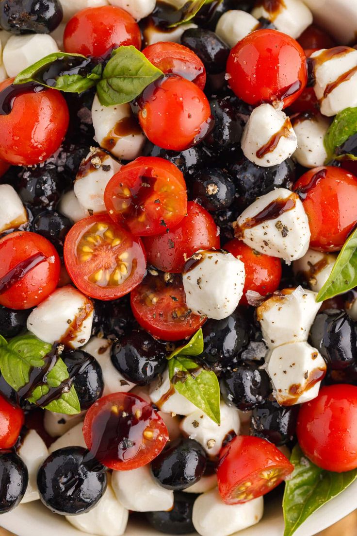 a salad with tomatoes, mozzarella and olives