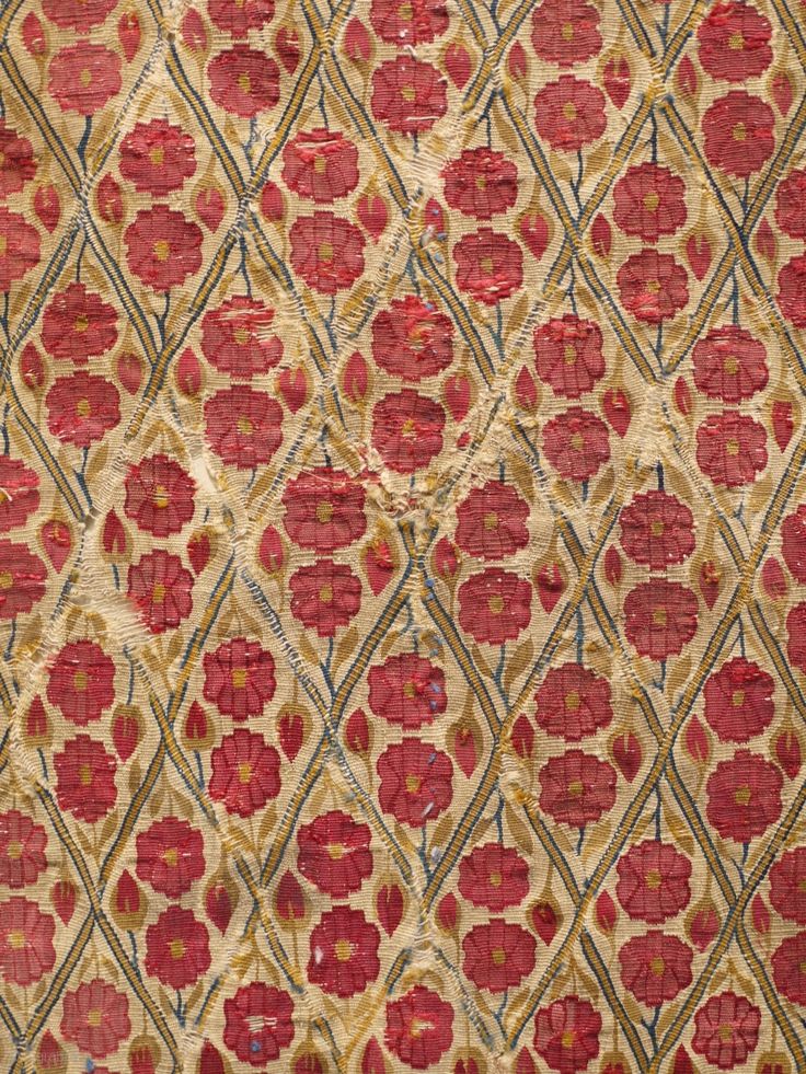 an old red and gold cloth with designs on it