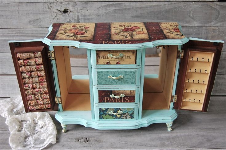 an old dresser with drawers painted blue and decorated with paris themed images on the doors