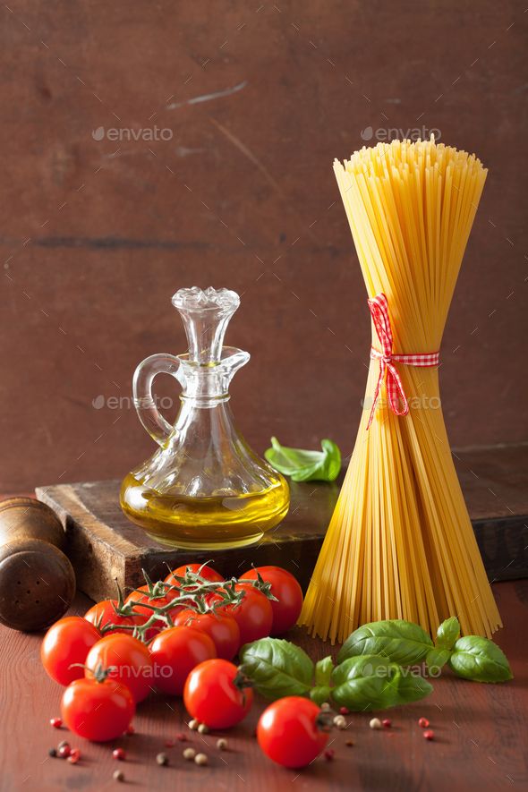 spaghetti, tomatoes and basil on a wooden table - stock photo - images in gallery