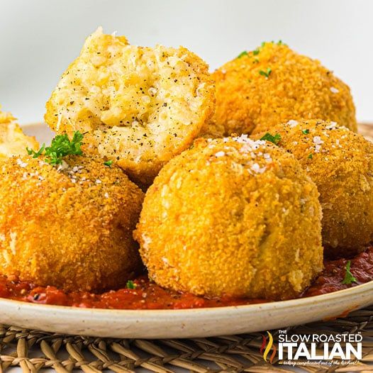 some fried food is on a plate with marinara sauce and parmesan bread