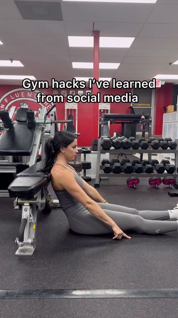 a woman sitting on the ground in a gym