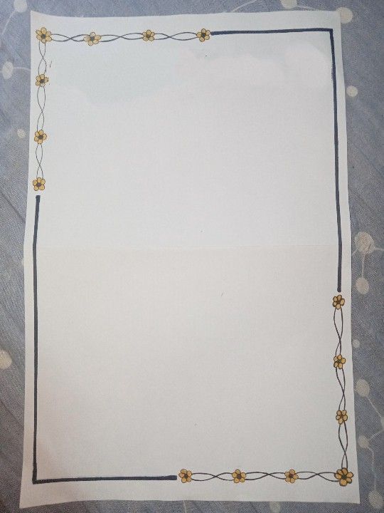 a piece of white paper with gold flowers on it