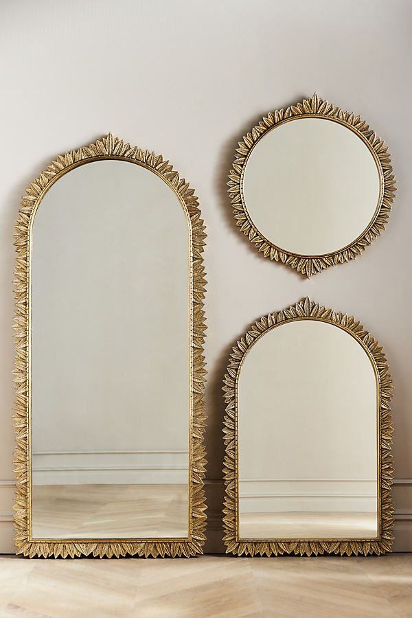 two mirrors sitting next to each other on top of a wooden floor in front of a wall