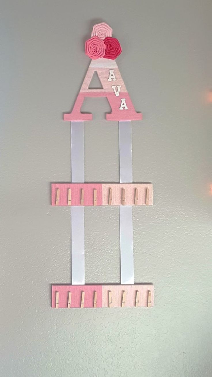 a pink and white wall hanging with letters