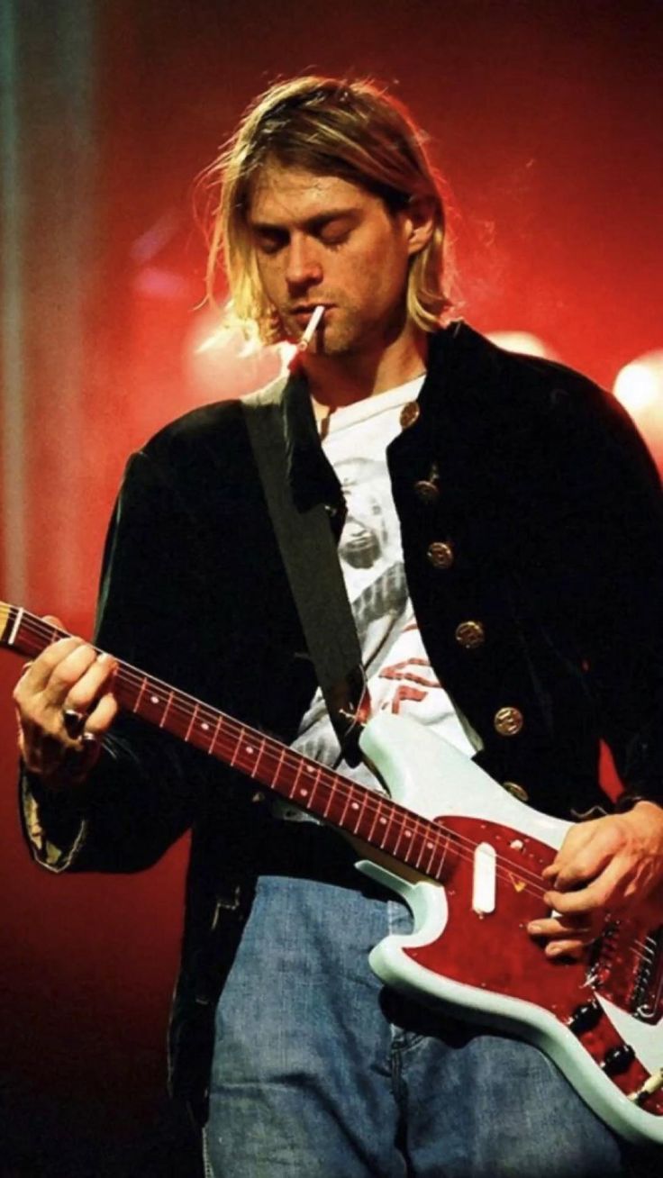 a man with long hair playing an electric guitar