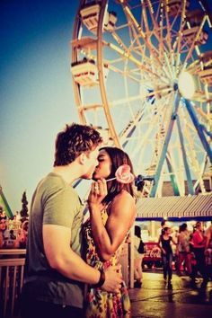 a man and woman kissing in front of a ferris wheel with the words, so i wonder around this town hill summer comes around