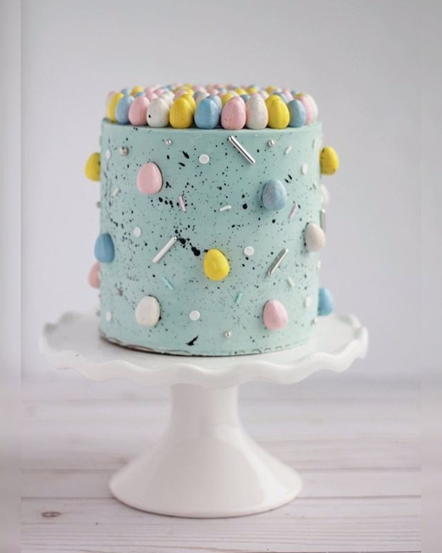 there is a blue cake with white frosting and colorful candies on the top