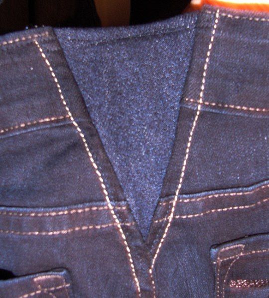 a close up of a pair of blue jeans with white stitching on the back