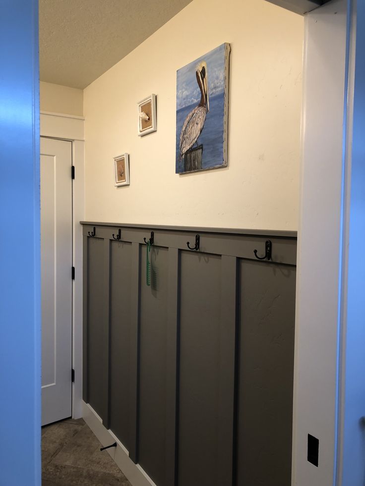 a hallway with several gray lockers on the wall and pictures hanging above each door