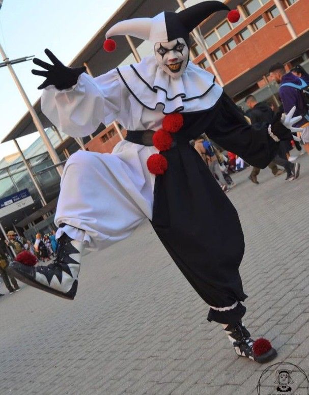 a man dressed as a clown is performing on the street