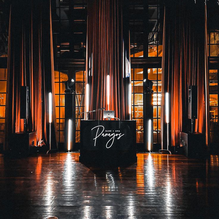 an empty stage set up for a party with orange drapes on the walls and floor