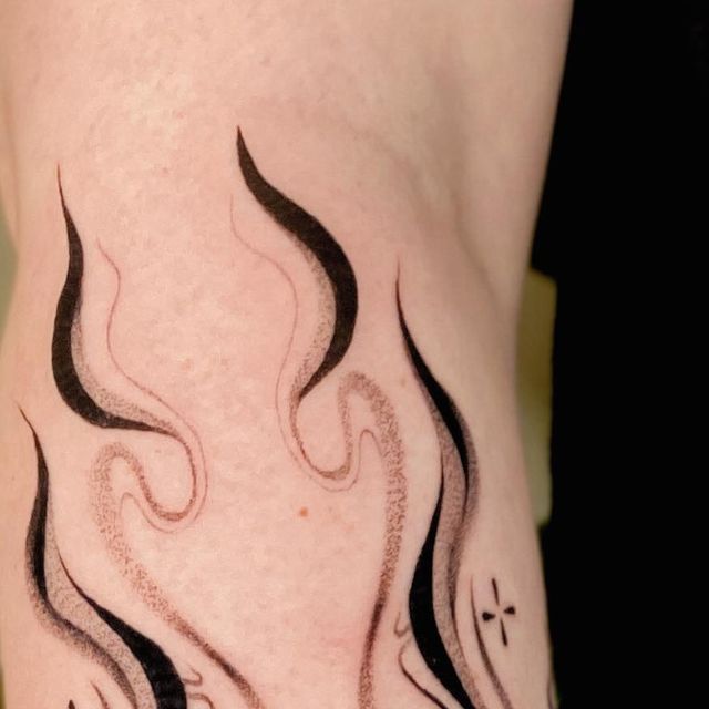 a man with a tattoo on his arm that has flames coming out of the back