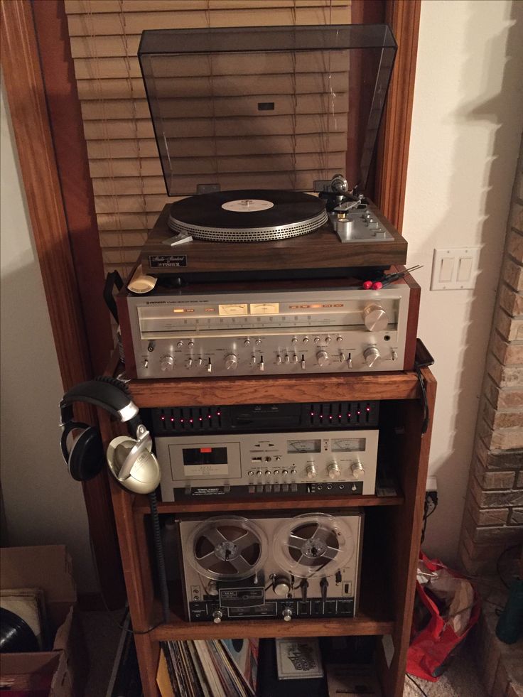 an old record player sits on top of a shelf next to other records and cassette players