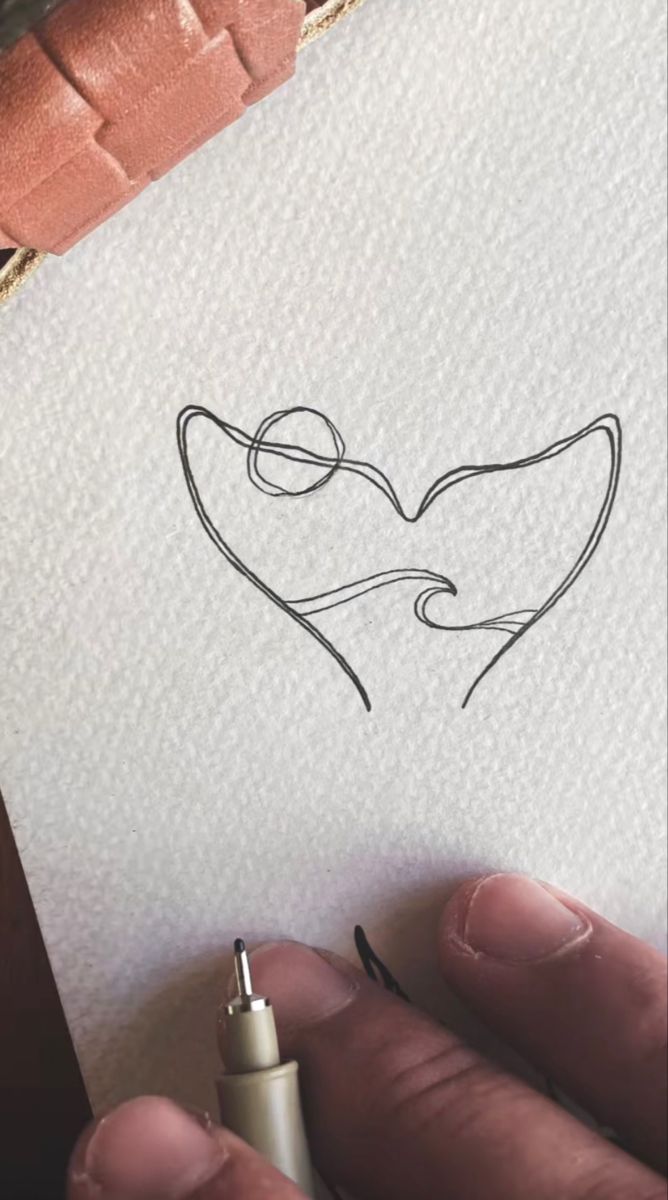 a person holding a piece of paper with a drawing on it