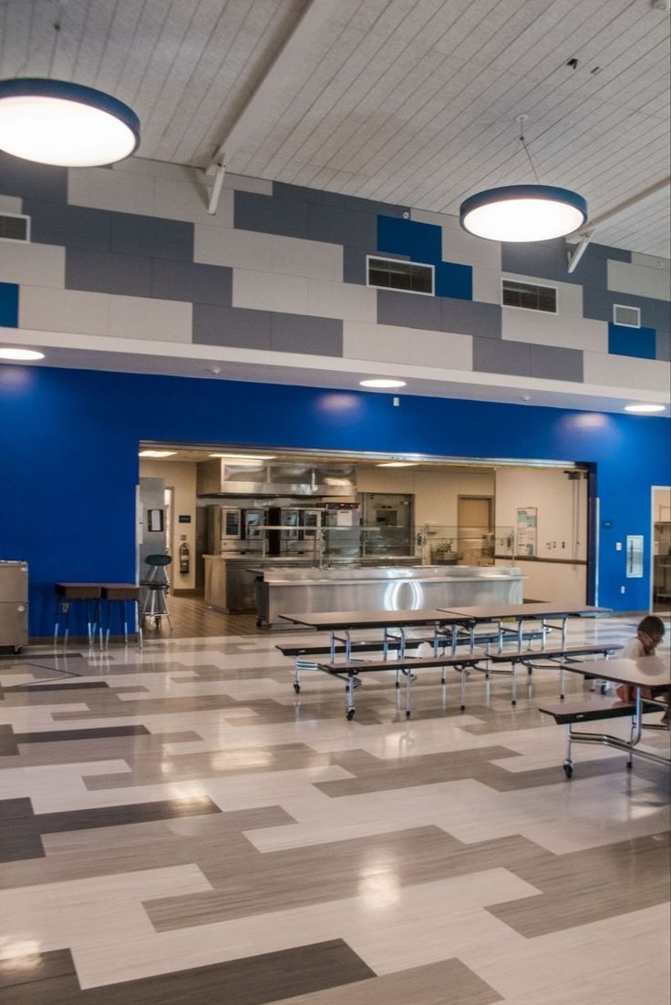 an empty cafeteria with tables and benches in it