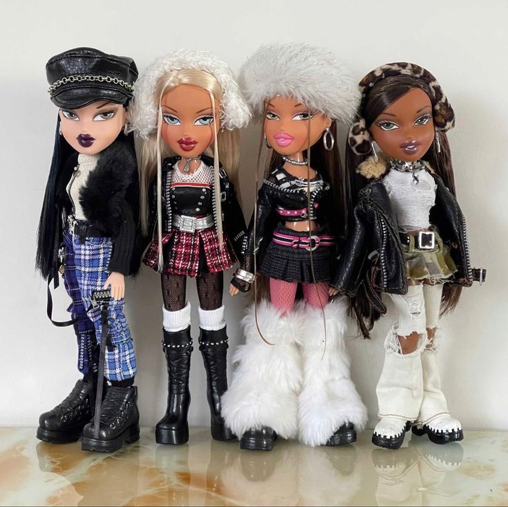 three dolls are standing next to each other in different outfits and hair styles, one is wearing a hat