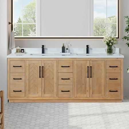 a bathroom vanity with two sinks and mirrors on the wall next to a potted plant