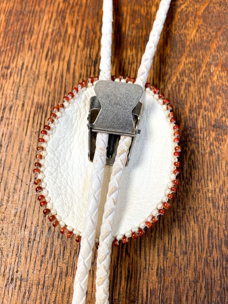 Soft leather, bead and agate bolo tie with stamped silver end tips. Artisan made with extraordinary detailed bead work. Hang length 18" Bolo 2"(w) x 2 3/8"(h) Tassels 2” long Condition: Very good. One tassel is slightly bent. Handmade Lariat Bolo Tie For Rodeo, Artisan Bolo Ties With Sliding Knot As Gift, Artisan Bolo Ties With Sliding Knot For Gift, Artisan Bolo Tie With Sliding Knot As Gift, Handmade Bolo Ties As Unique Gifts, Handmade Southwestern Lariat Bolo Tie, Artisan Adjustable Bolo Ties For Gifts, Artisan Lariat Jewelry For Rodeo, Artisan Lariat Bolo Tie With Adjustable Length