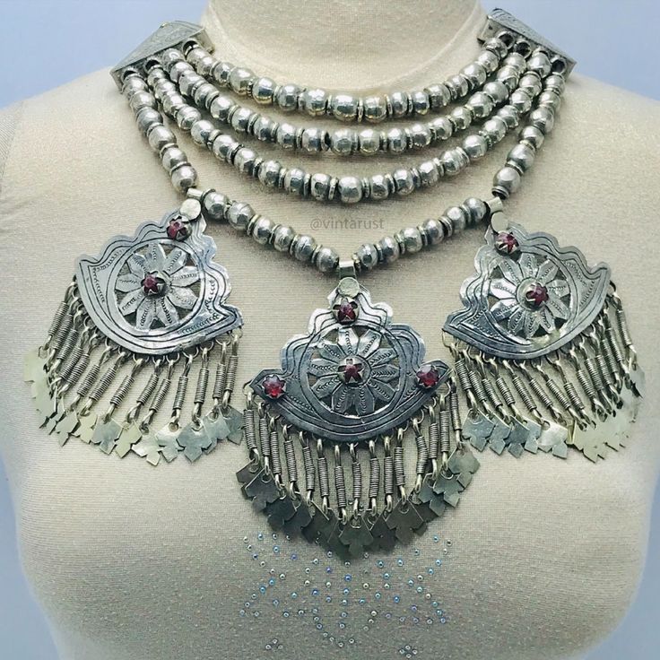 Massive Boho Beaded Chain Afghan Necklace. This multilayer silver beads tribal choker necklace has three vintage-inspired pendants which are making this tribal ornament an eye-pleasing jewelry piece. The best quality metal alloy is used to make this ethnic tribal piece. Glass stones and drooping silver tassels are increasing the charm and elegance of this tribal necklace. This Afghani tribal choker necklace gives a full ancestral and traditional look to you whenever you wear it. Bohemian Metal Jewelry With Large Beads, Silver Bohemian Beaded Necklaces, Vintage Handmade Silver Beads, Handmade Vintage Silver Beads, Bohemian Necklace With Silver Beads For Ceremonial Use, Silver Beaded Chain Jewelry For Festivals, Vintage Silver Beaded Necklace For Festival, Silver Jewelry With Beaded Chain For Festivals, Bohemian Antique Silver Necklaces With Silver Beads