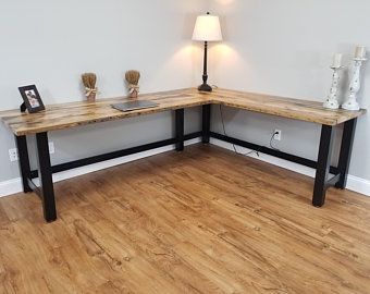 a corner desk in the corner of a room with a lamp and pictures on it