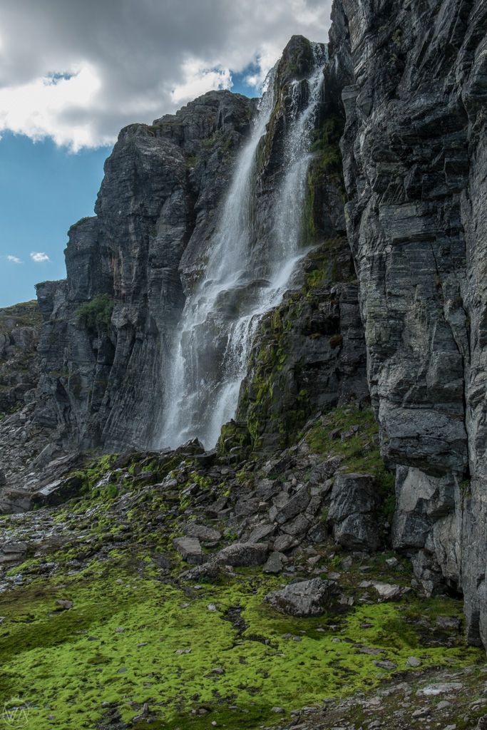 a large waterfall cascading into the side of a mountain