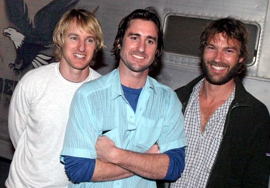 three men standing in front of an airplane