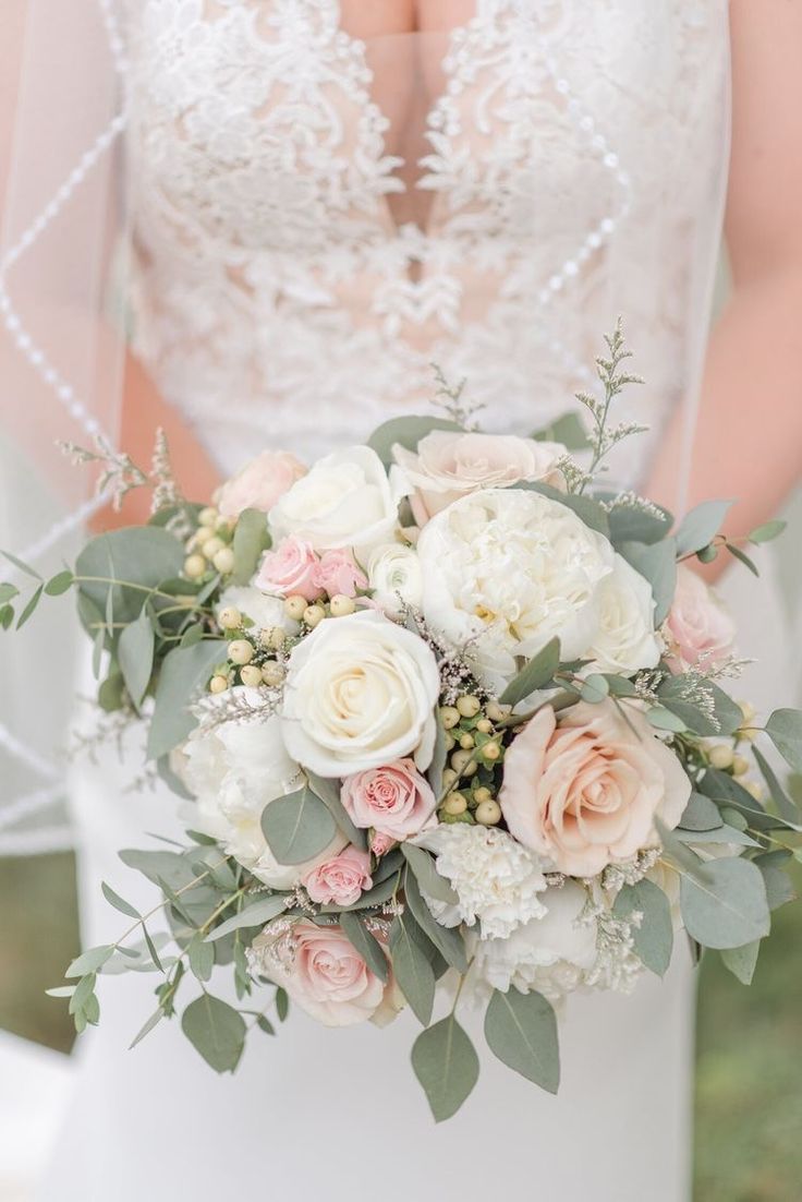 a bridal holding a bouquet of white and pink flowers