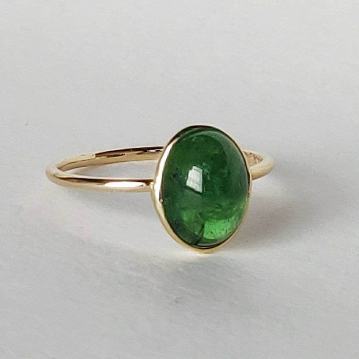 ITEM DESCRIPTION: >> The Ring is made from Solid 14K Yellow Gold. Gemstone used is absolutely natural and ethically sourced. >> Natural deep green emerald coloured garnet popularly known as Tsavorite in oval shape is studded on it with utmost precision. >> This is a minimalist design which makes it a hassle free and everyday jewelry. Gem: Tsavorite Gem size: 7.5x10 mm and Pear Shape Gem weight: Gemstone option 1 : 2.54 carats Gemstone option 2 : 2.99 carats Gemstone option 3 : 2 Stone Pendant Design, Green Tsavorite Rings With Bezel Setting, Green Oval Sapphire Ring In 14k Gold, Green Sapphire Ring In 14k Gold, Oval Green Sapphire Ring In 14k Gold, Oval Tsavorite Ring With Bezel Setting, Green Tsavorite Birthstone Ring, Tsavorite Jewelry, Maximalist Jewelry